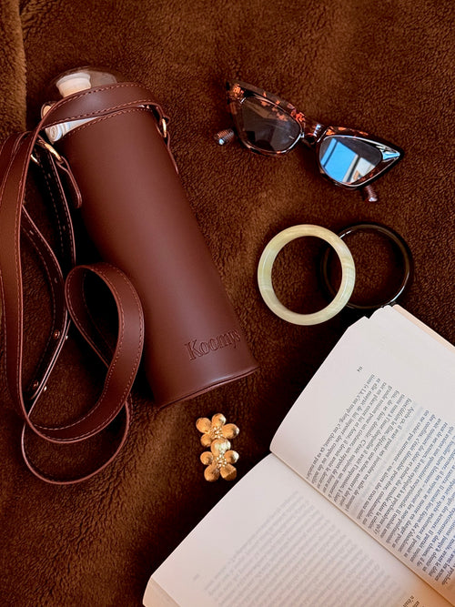 Fashion inspiration avec le porte gourde marron koomys. Lunette livre bracelet et boucle d'oreille. S'hydrater en restant fashion