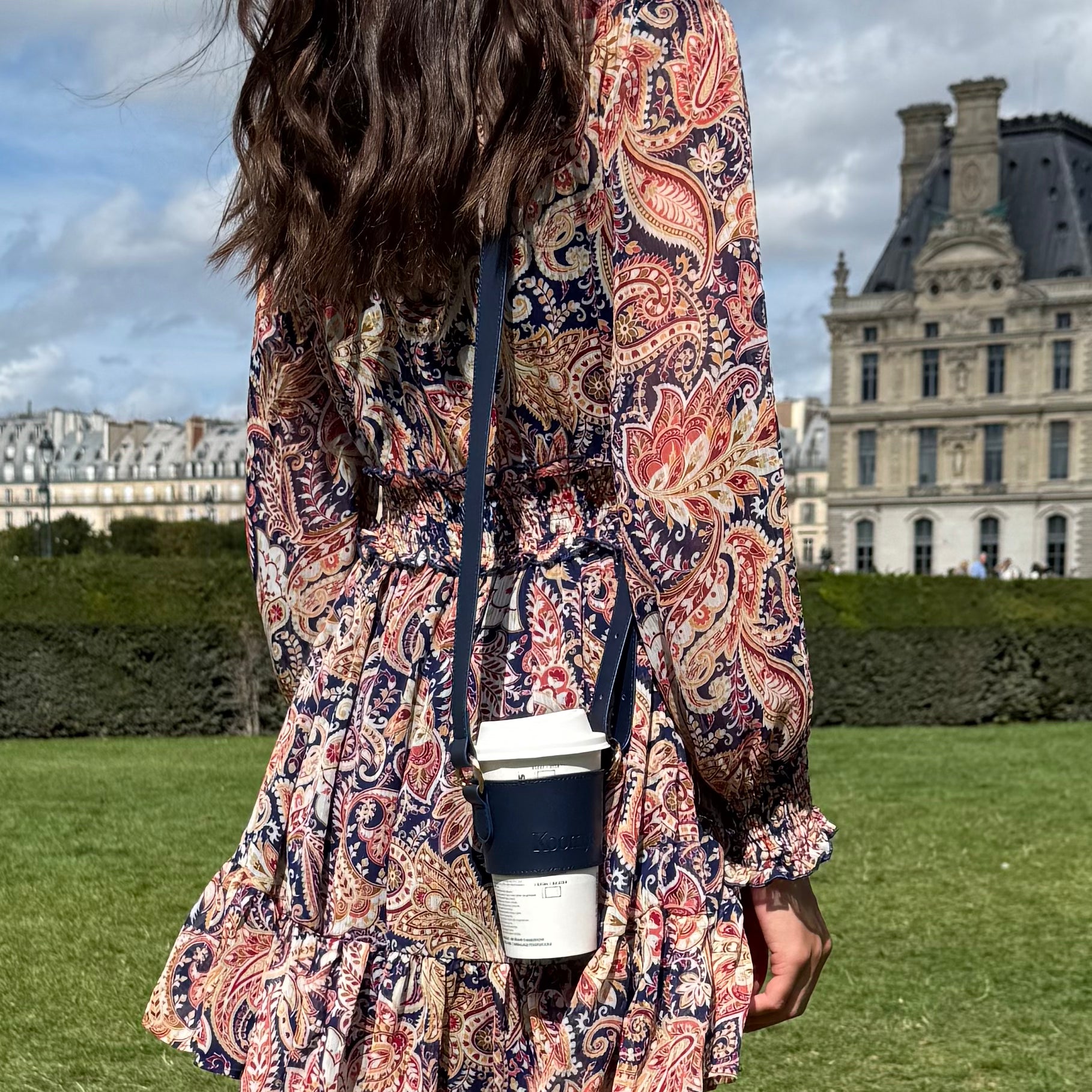 Femme portant un porte-gobelet en cuir vegan bleu KOOMYS avec café à emporter