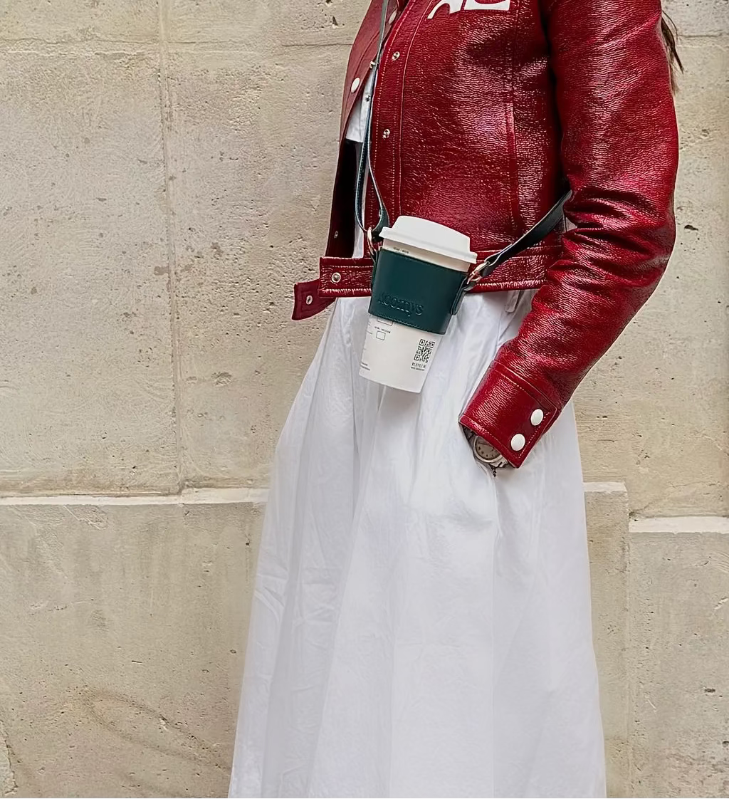 Femme portant un porte-gobelet en cuir vegan vert KOOMYS avec café à emporter