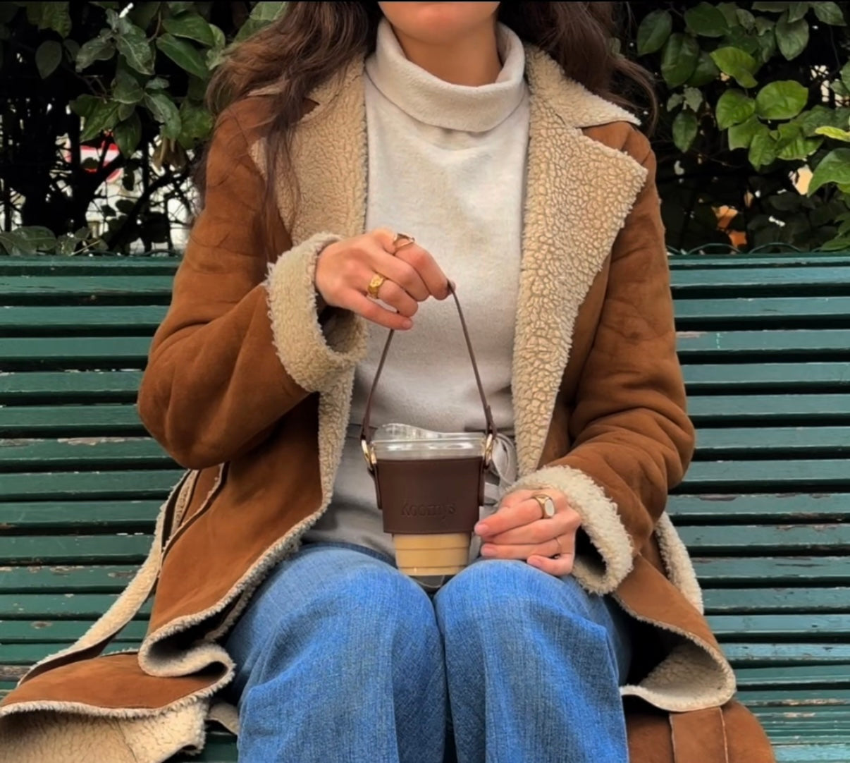 Personne assise sur un banc avec porte-gobelet KOOMYS en cuir vegan marron
